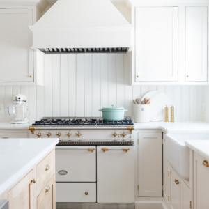 A kitchen with white cabinets and a blue anti fatigue kitchen mat.