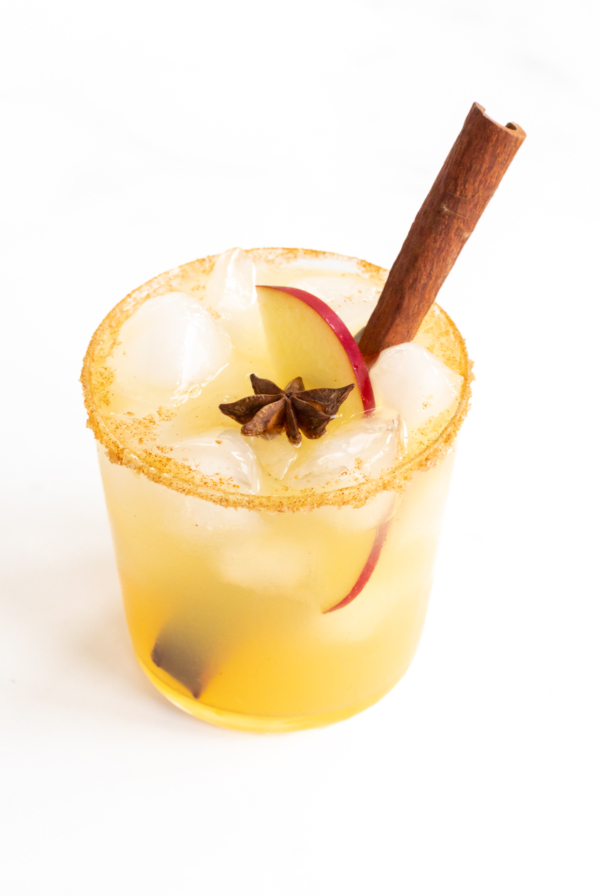 An apple cider margarita garnished with a cinnamon stick.