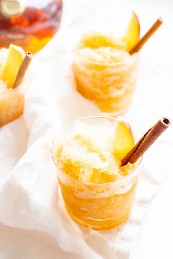 Apple cider slush with bourbon, garnished with a cinnamon stick