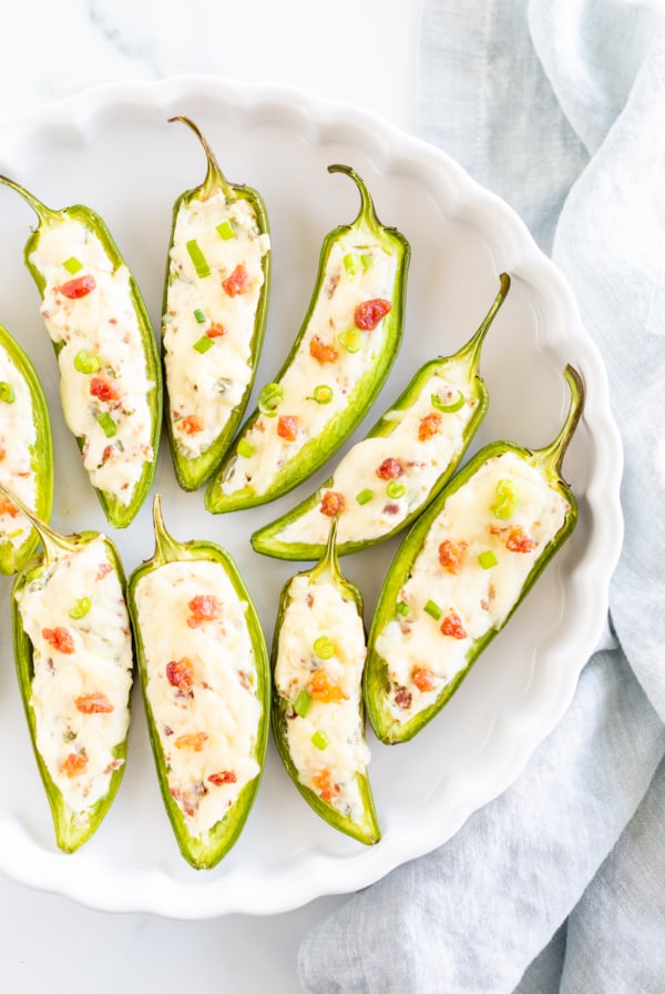 Stuffed jalapenos on a white plate.