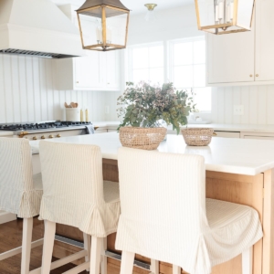 Kitchen island bar stools with striped slipcovers in a white kitchen