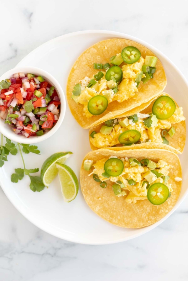 Three breakfast tacos on a white plate