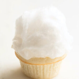 A cotton candy-topped ice cream cone against a plain background, resembling Easter cupcakes.