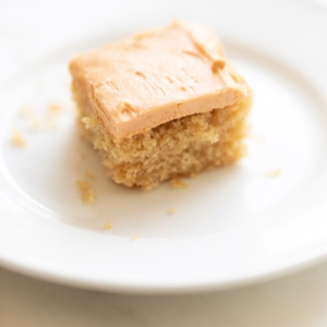 A slice of butterscotch cake on a white plate.