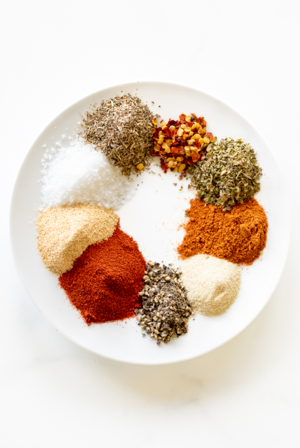 Various spices on a white plate for a homemade cajun seasoning recipe.