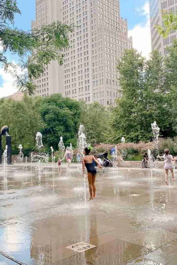 Concrete foundtain/ splash park with St. Louis high rise in background.