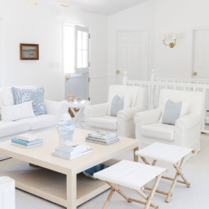 A white coffee table with soft blue and white coffee table decor.