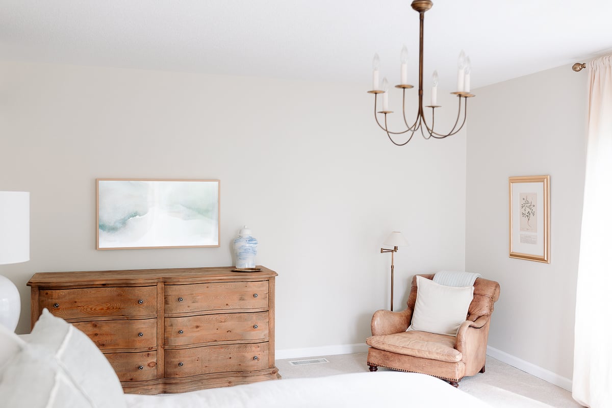 A bed in a bedroom with curved dressers.