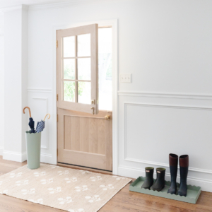 A doorway with a rug and a pair of boots.