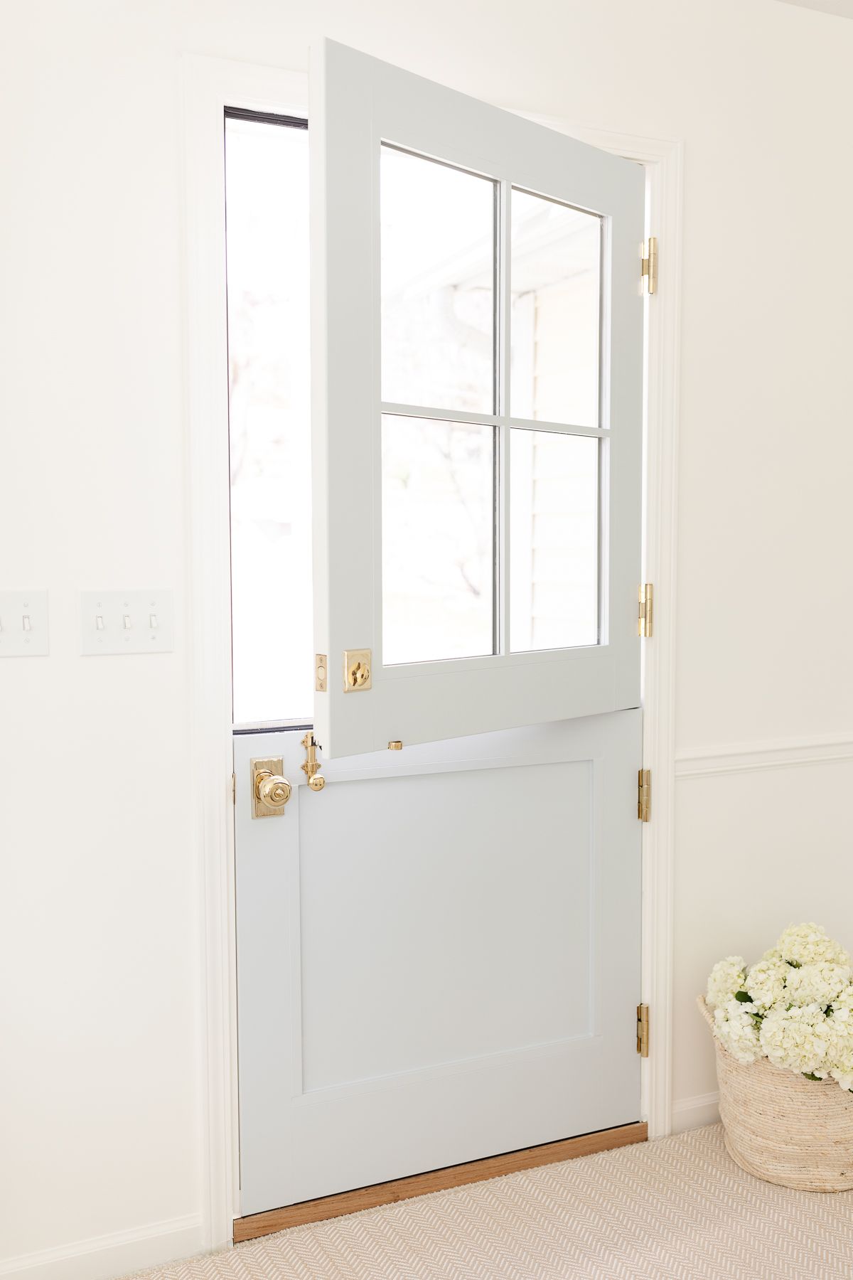 A blue dutch door with brass hardware