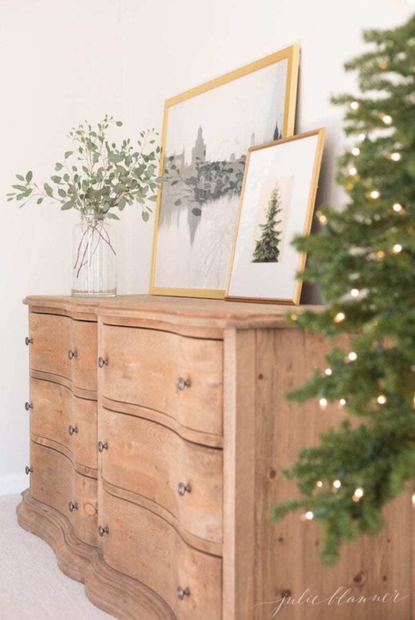 A soft wood dresser in a bedroom with simple Christmas decor.