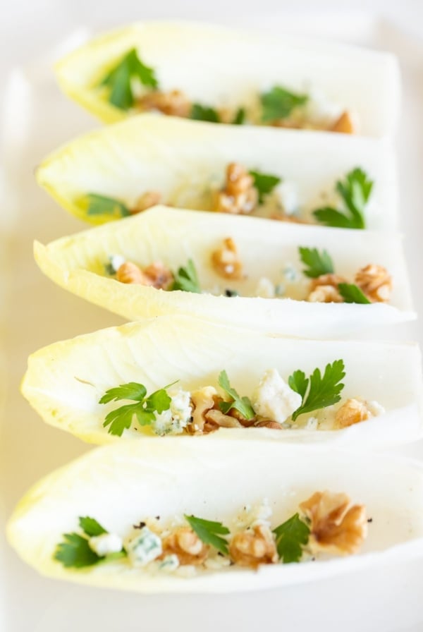 An endive salad laid out on a white platter.