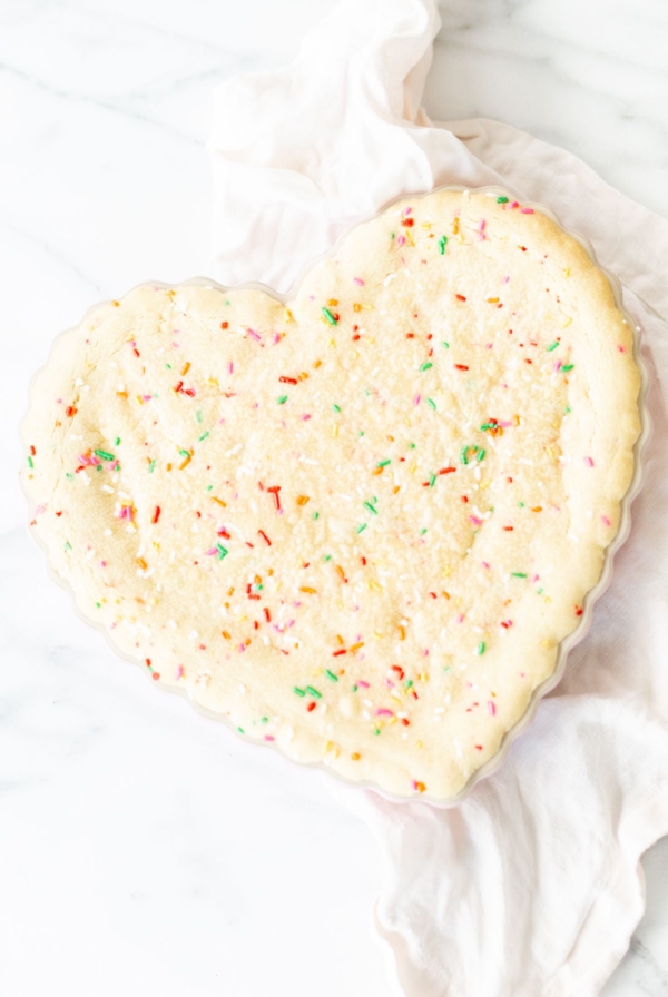 A funfetti cookie cake baked into a heart shaped pan.