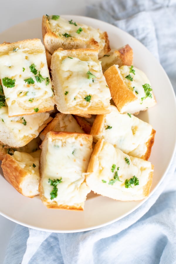 Overhead view of garlic cheese bread slices in serving bowl