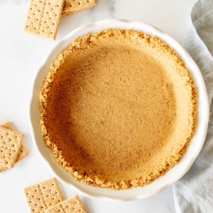 Graham cracker crust in a white pie plate.