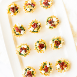 Spinach and artichoke cups on a white platter in an hors d'oeuvres recipe collection