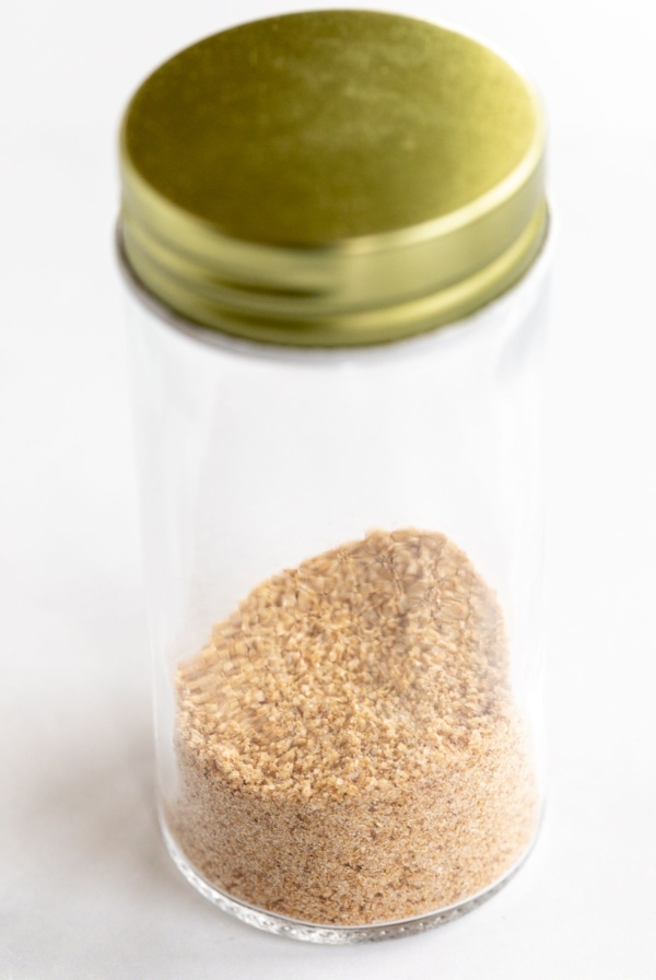 A clear glass jar with homemade beau monde seasoning recipe