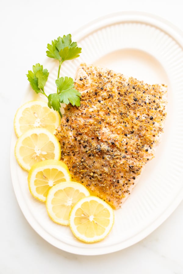 Lemon pepper salmon on a white platter.