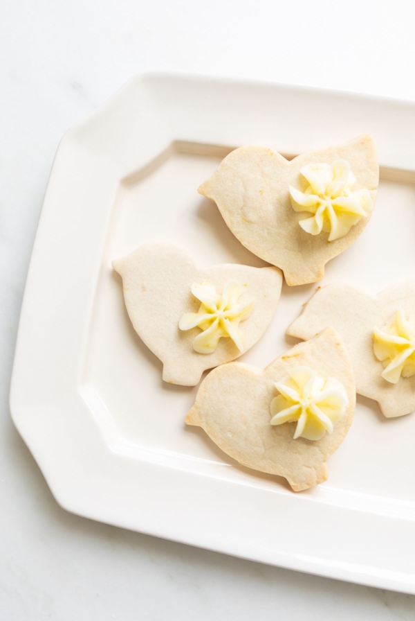 Frosted lemon shortbread cookies in a bird shape.