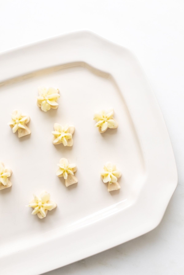 A white platter full of frosted key lime cookies.