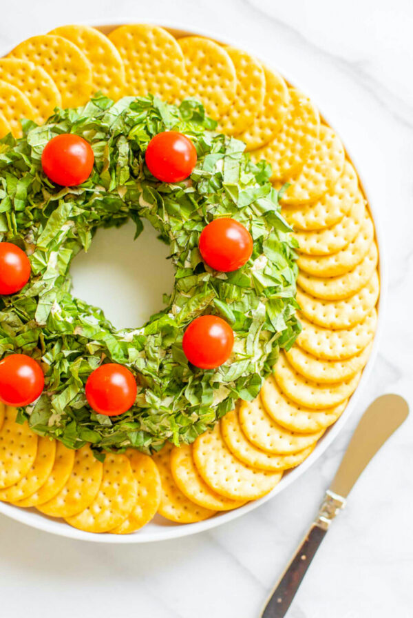 A basil pesto wreath make ahead christmas appetizer on a white plate