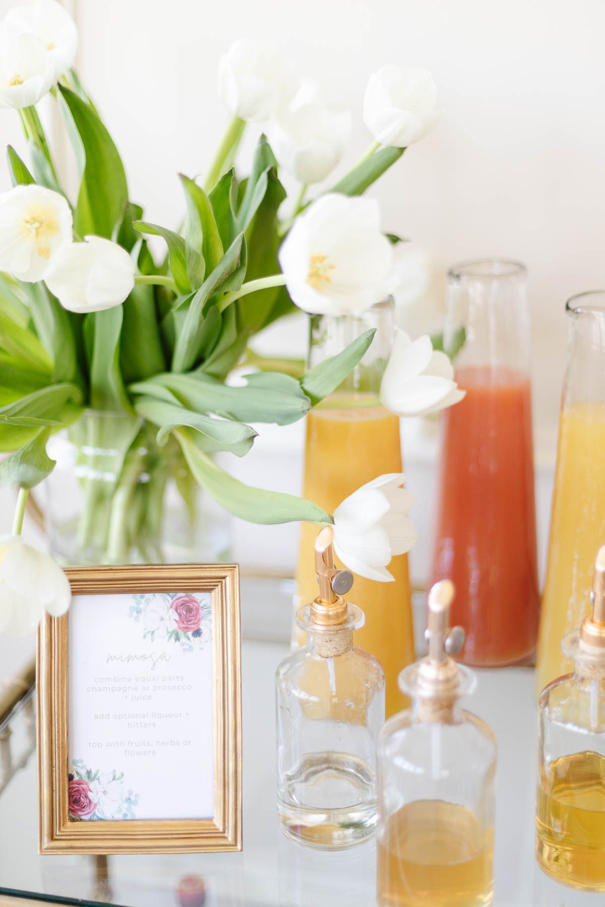 mimosa bar ideas with white tulips and fresh juices in glass bottles