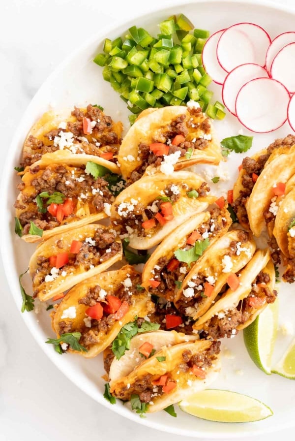 Beef mini tacos on a white platter.