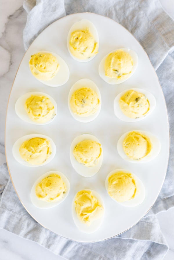 A white deviled egg platter featuring the world's best deviled egg recipe.