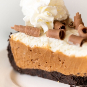 A slice of French silk pie on a white plate.