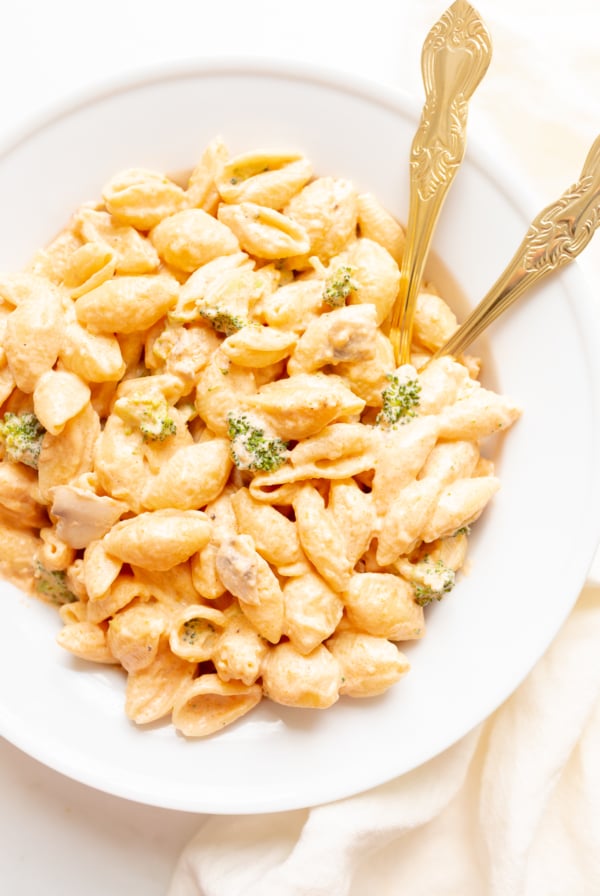 A white plate of pasta con broccoli.