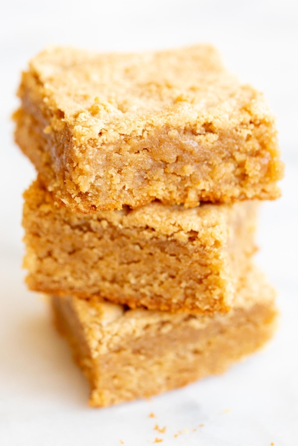 Stack of peanut butter brownies on a white surface