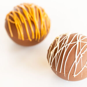 Two peanut butter chocolate easter eggs with icing on them.