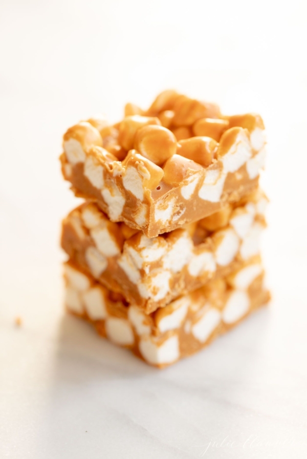 A stack of butterscotch peanut butter marshmallow bars on a marble countertop.