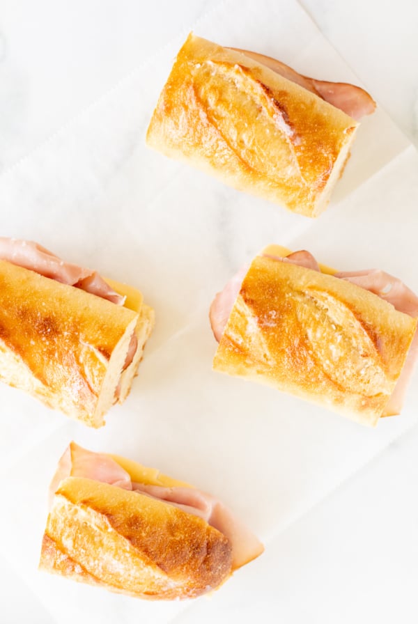 Four picnic sandwiches on a white sheet of paper.