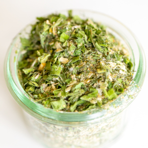 Glass jar of homemade ranch seasoning on a white countertop.