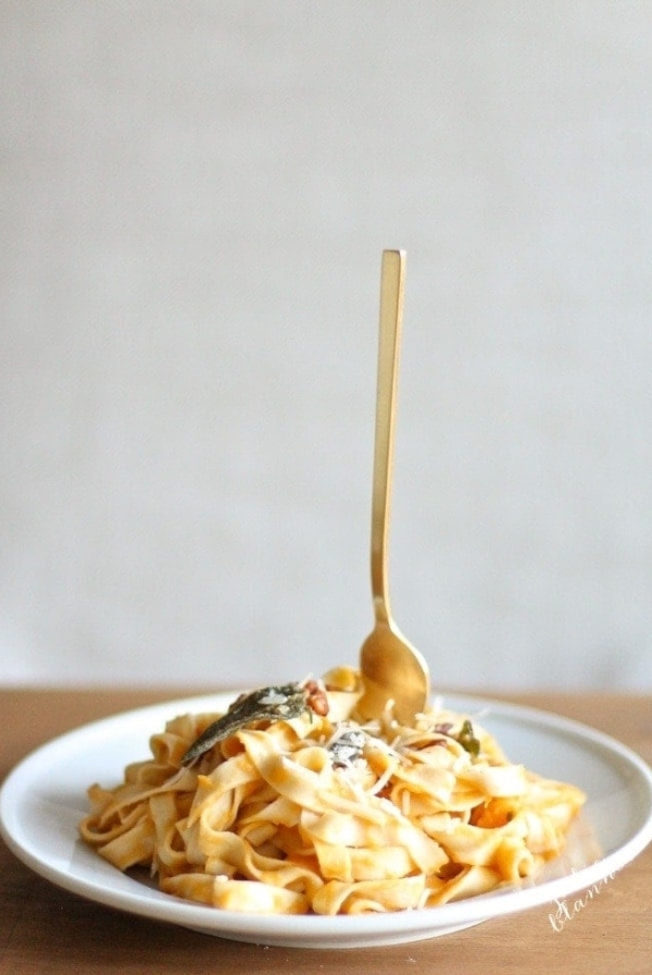 butternut squash pasta on white plate with fork sticking up