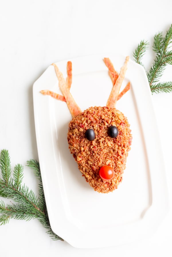 A plate with a reindeer head on it, holding a reindeer cheeseball.