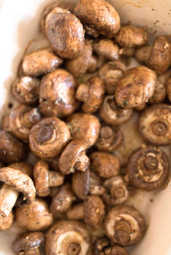 Oven Roasted Mushrooms in a white dish on a table.