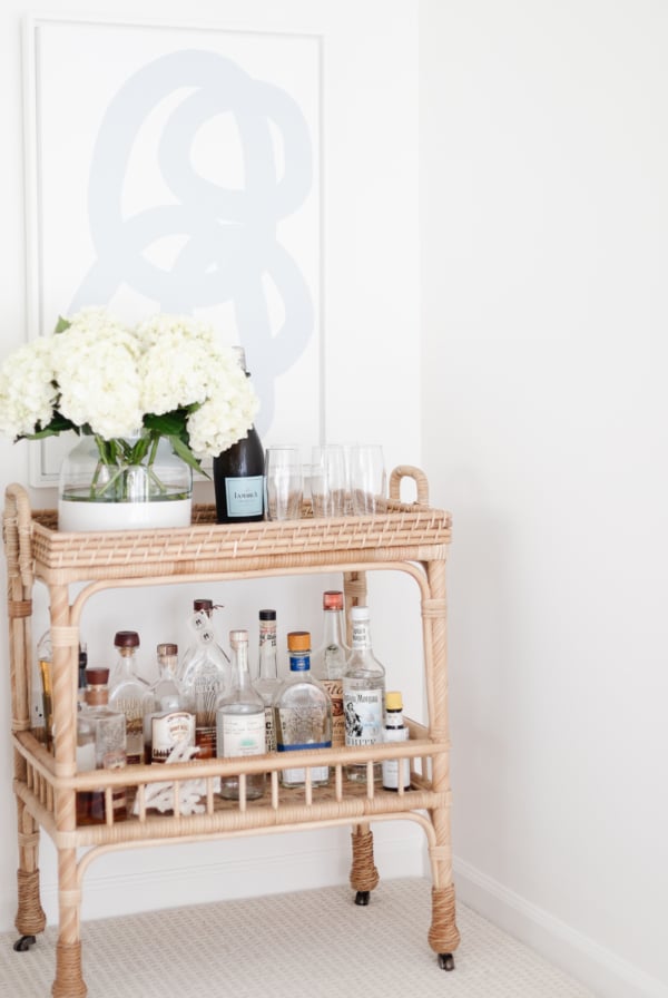 rattan bar cart with blue and white art over