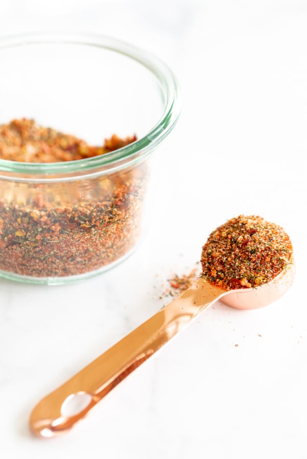 A bowl of the best steak seasoning with a spoon next to it.