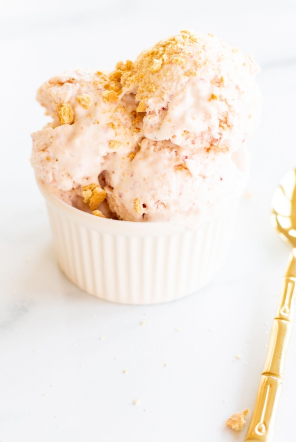 Strawberry cheesecake ice cream in a white bowl.