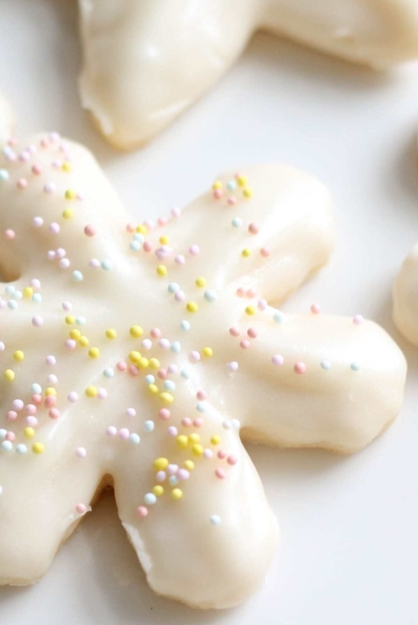 snowflake cookies covered in buttercream icing and sprinkles