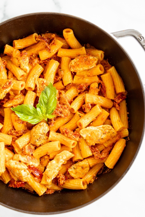 Sun dried tomato chicken pasta in a cast iron skillet.